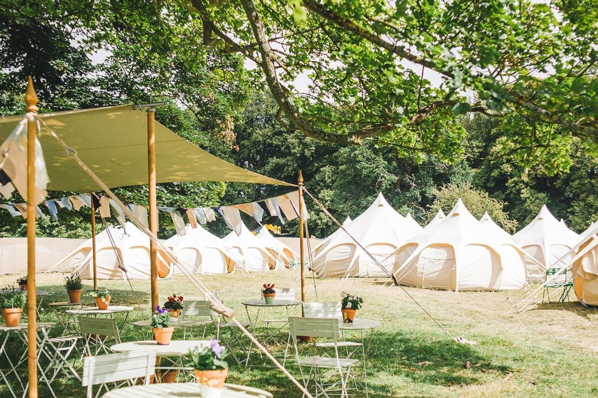A row of teepee tents on a field at Wilderness Festival in Oxfordshire