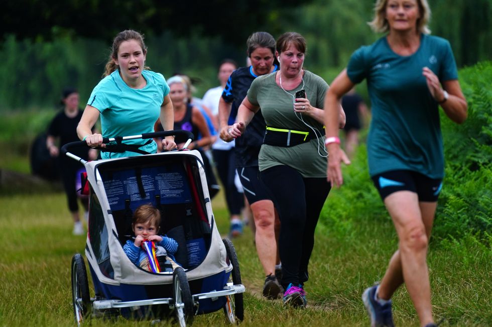 A runner pushes her buggy during Parkrun (Victoria Jones/PA)