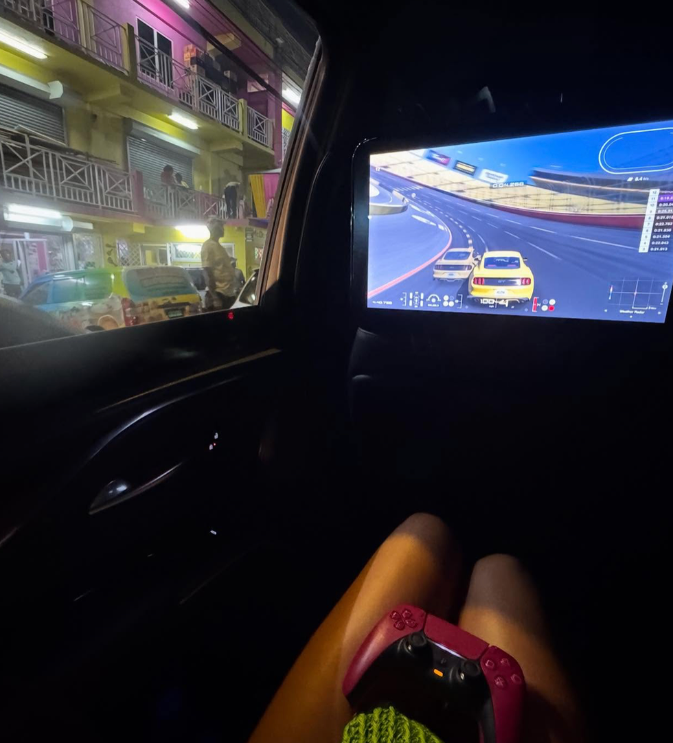A screenshot of one of Dua Lipa's Instagram posts of her playing Gran Turismo in the back of a vehicle