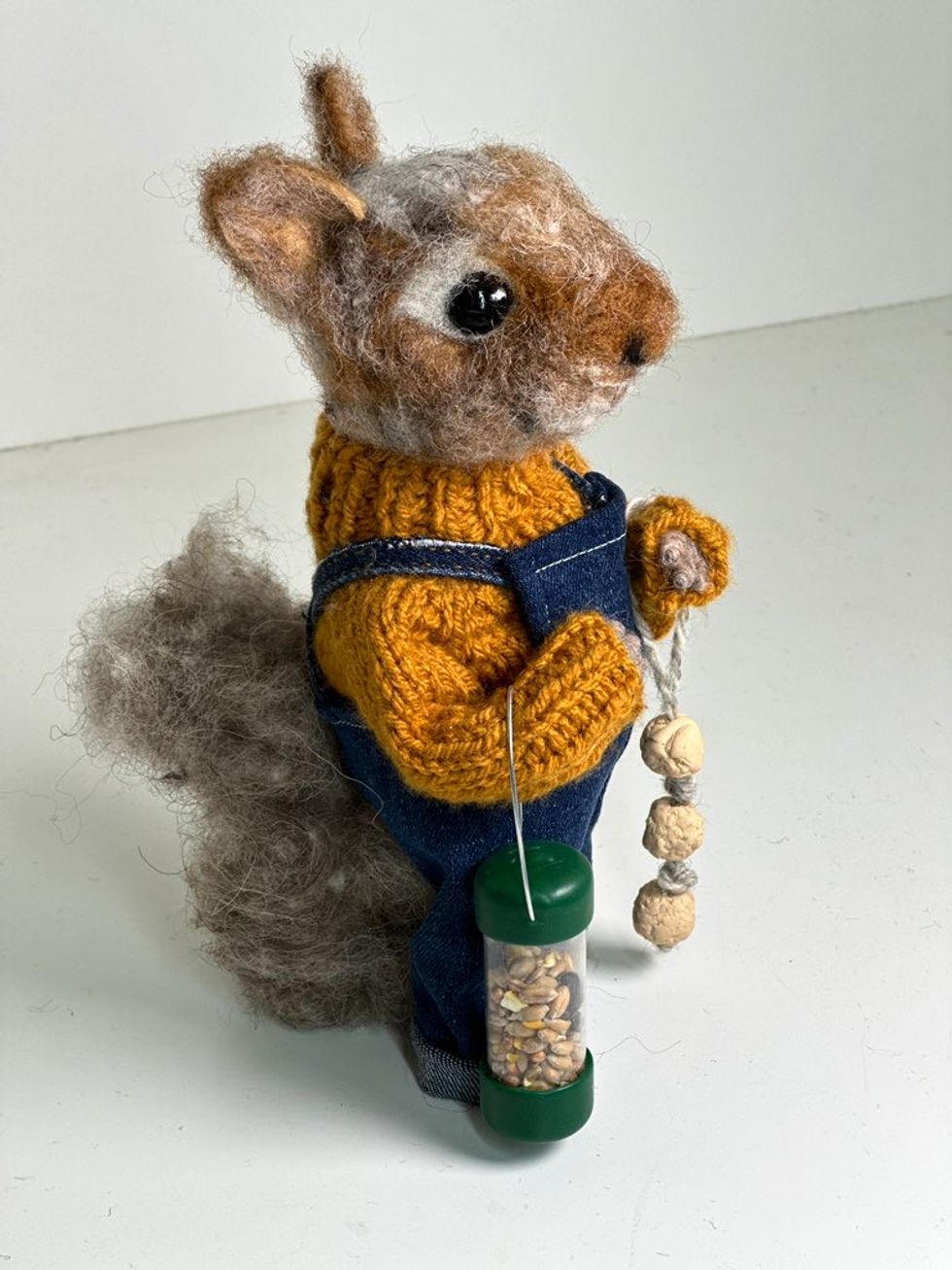 A sculpture of a mouse wearing dungarees and a sweater