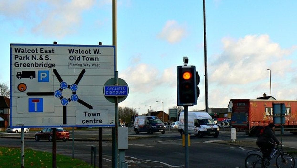 A sign for the Magic Roundabout in Swindon, showing five protruding lines connected by a pentagon in the middle.