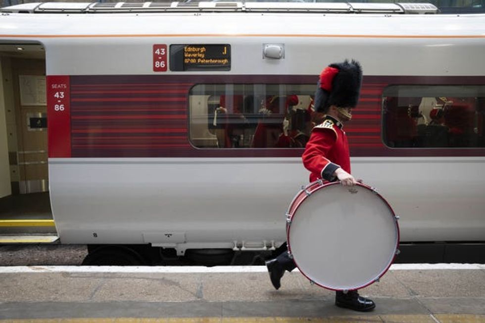A soldier carries a drum