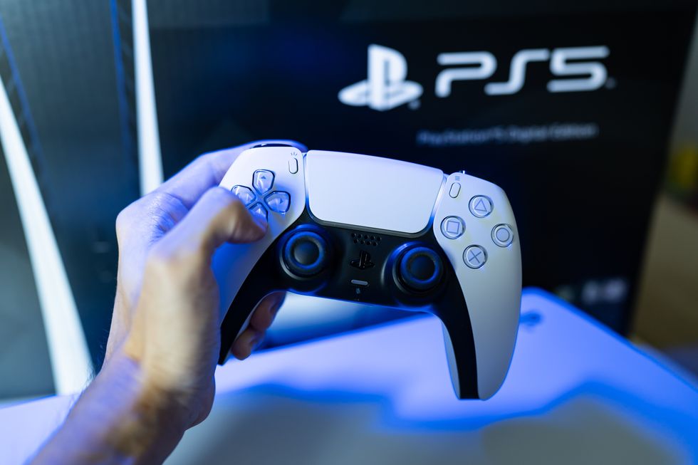 A stock image of a gamer playing PlayStation 5 game console with DualSense controller