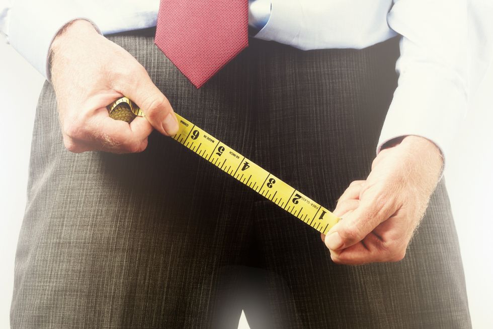A stock image of a man appearing to measure his crotch