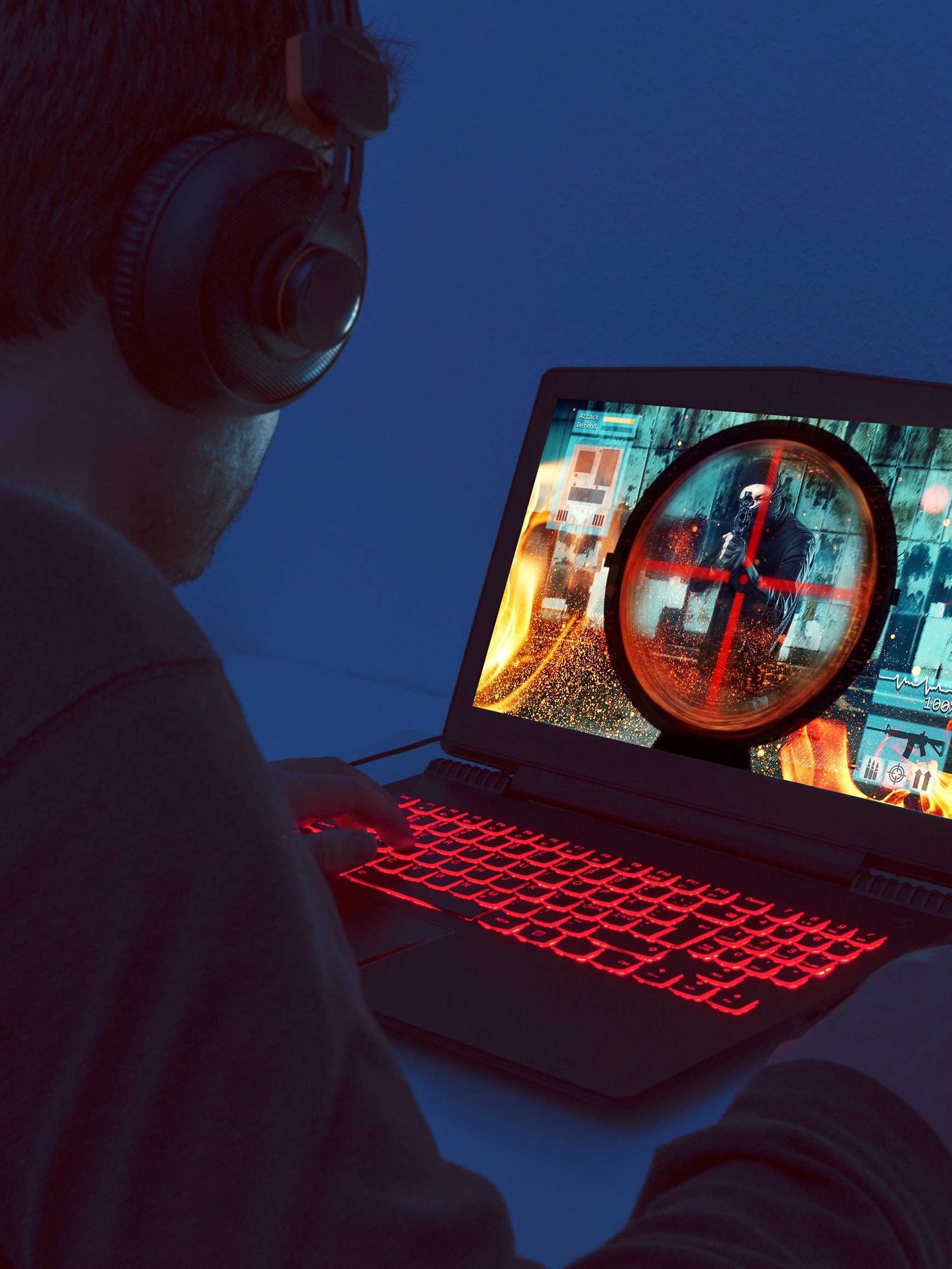 A stock image of a man playing on a gaming laptop