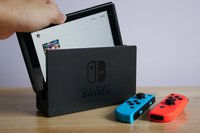A stock image of a Nintendo Switch console on a wooden table