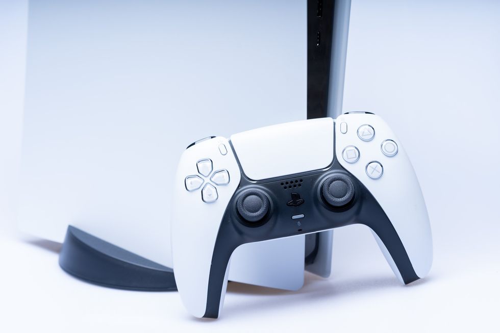 A stock image of a PS5 controller in front of a PS5 console