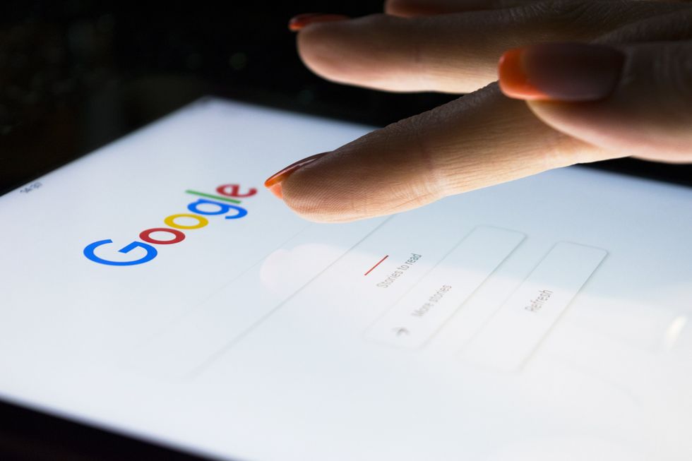 A stock image of a woman scrolling through Google on an iPad