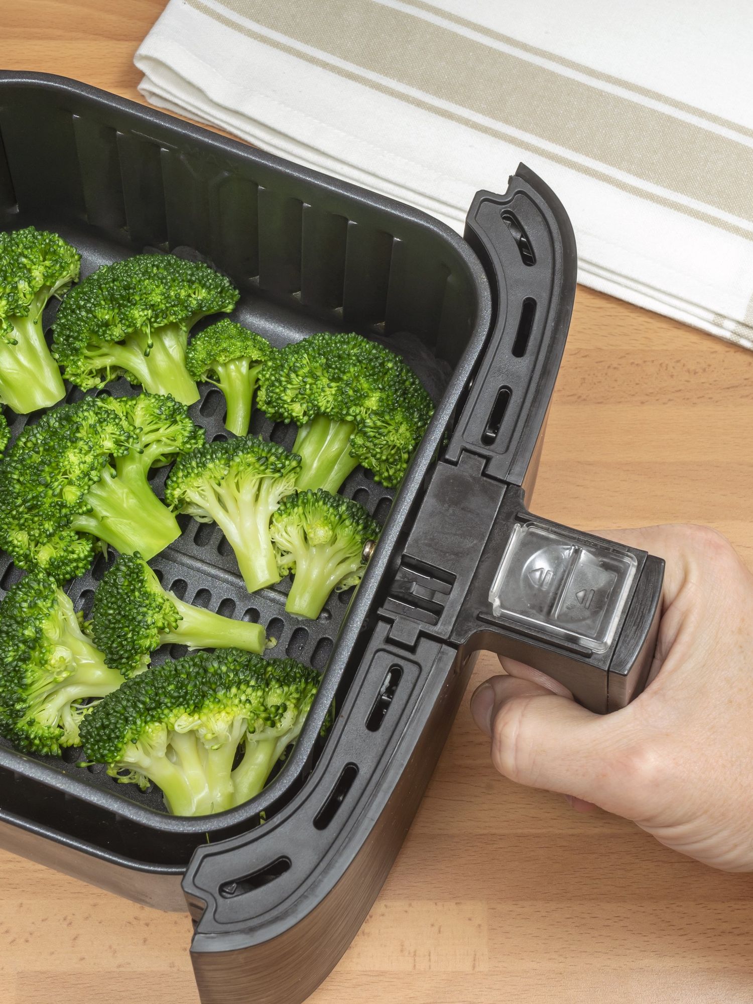 A stock image of broccoli being cooked in an air fryer
