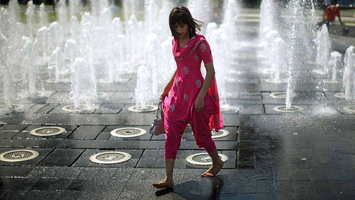 A student cools off in the fountains of Piccadilly Gardens in Manchester. Picture: Christopher Furlong/Getty Images