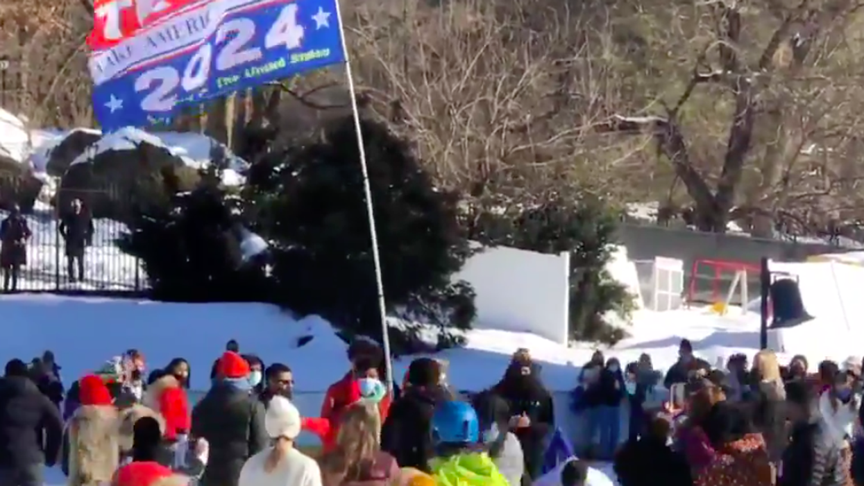 <p>A supporter of Donald Trump waved a huge Trump 2024 flag across a New York ice skating rink</p>