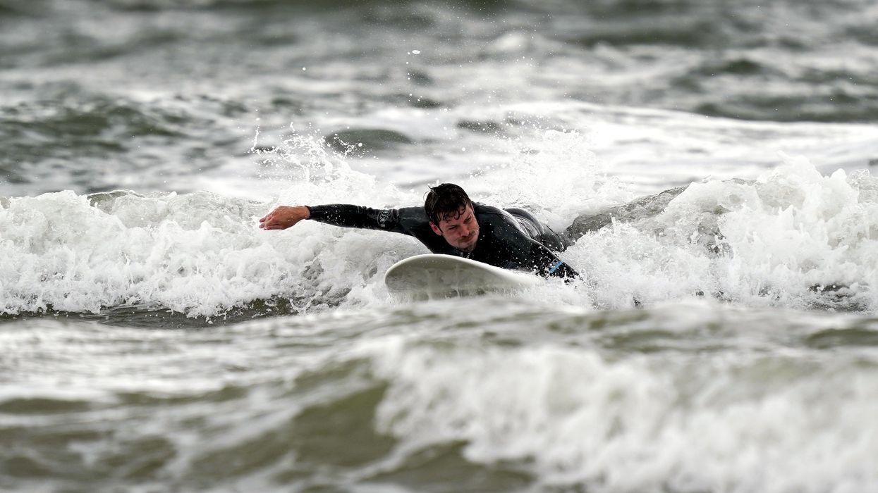 A surfer enjoys the waves in Porthcawl, Wales