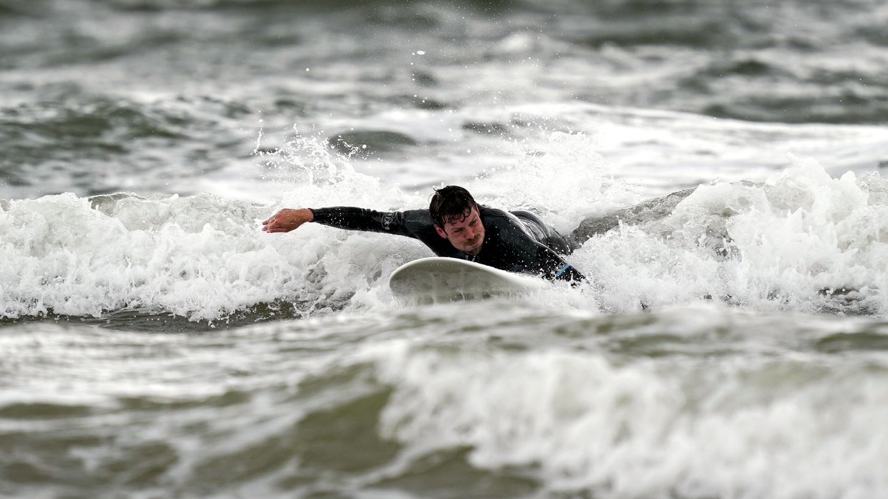 A surfer enjoys the waves in Porthcawl, Wales
