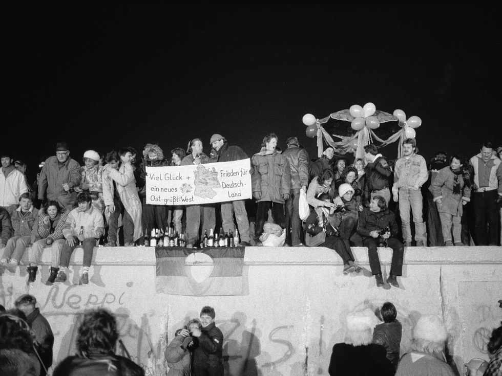 A view from the east of Berliners gathered on the Berlin Wall to celebrate the New Year and the effective end of the city's partition, 1989