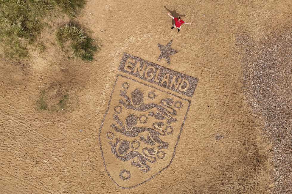 Artist crafts England badge on beach as World Cup campaign nears kick-off