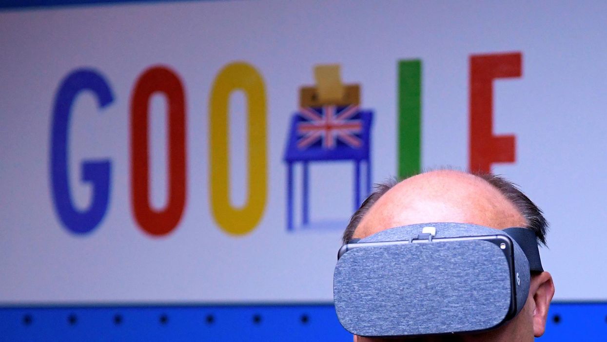 A visitor tries a pair of VR glasses with a smartphone at the Google digital workshop stand at the Labour party Conference in Brighton, Britain, September 24, 2017