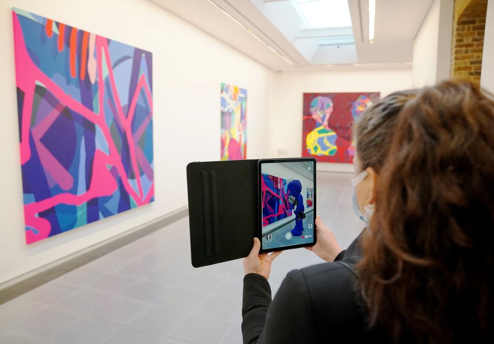 A visitor uses the augmented reality application on their tablet to view the work (Jonathan Brady/PA)