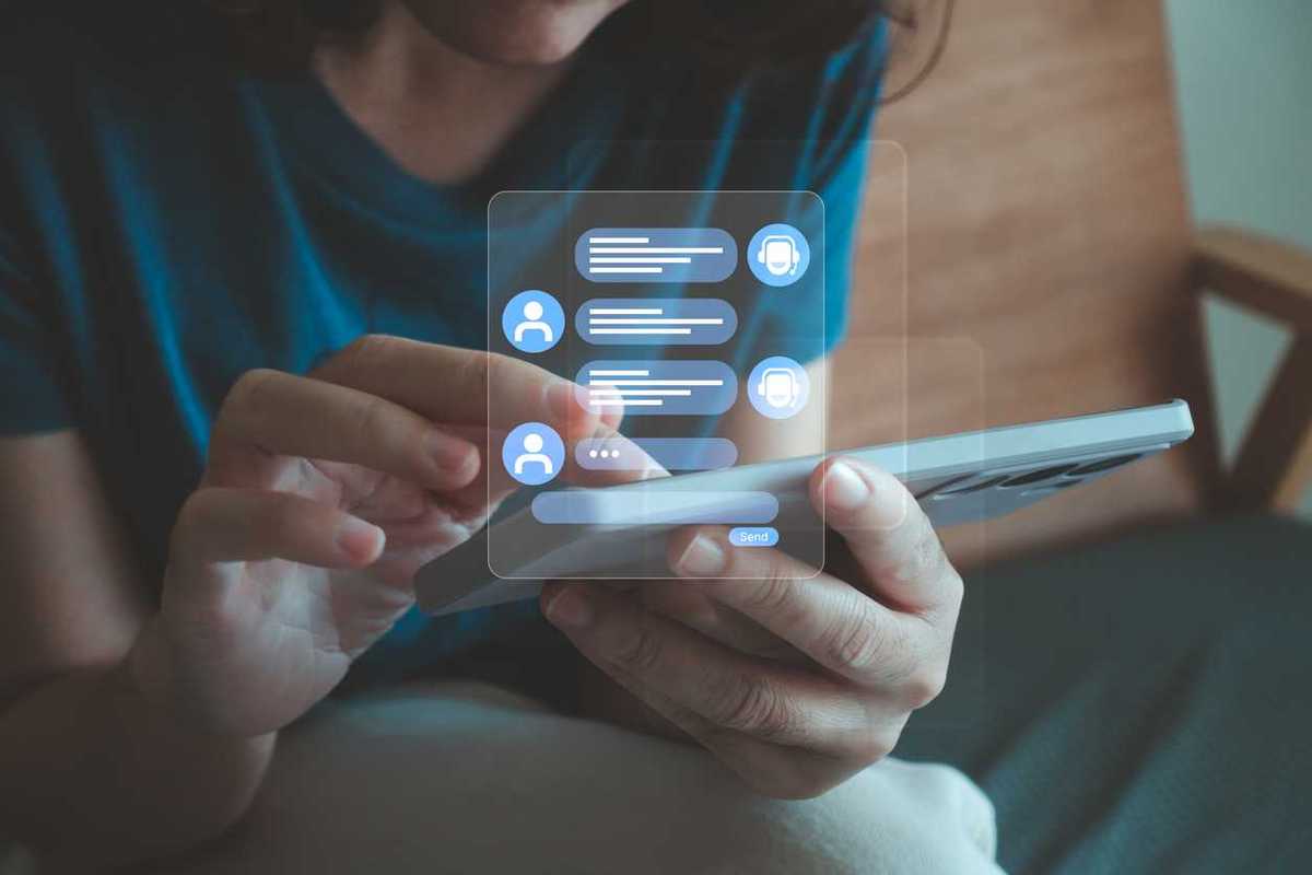 A white woman types messages into her phone, with a holographic text conversation appearing above it.