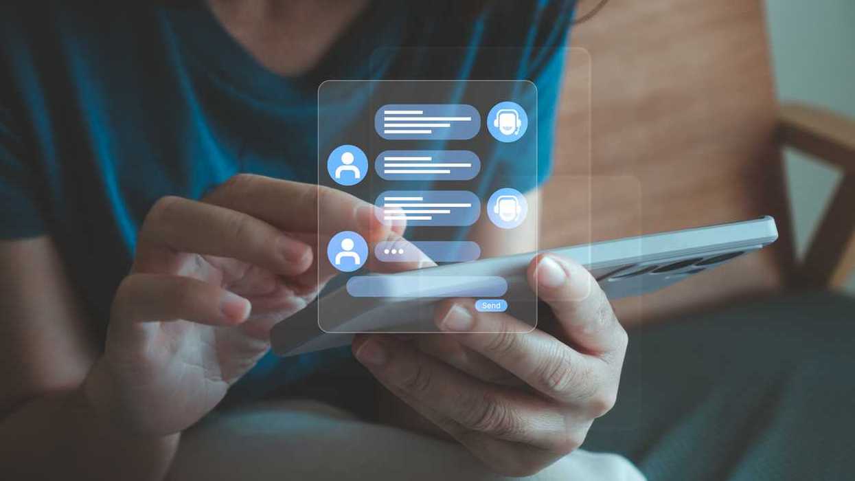 A white woman types messages into her phone, with a holographic text conversation appearing above it.