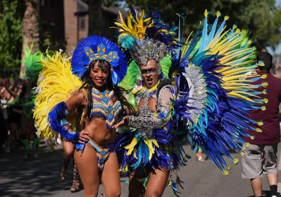 A woman and man in feathered wings of blue and gold