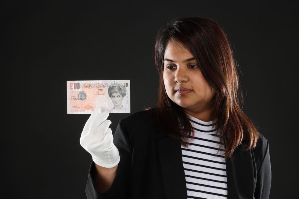 A woman holding Di-Faced Tenner by Banksy