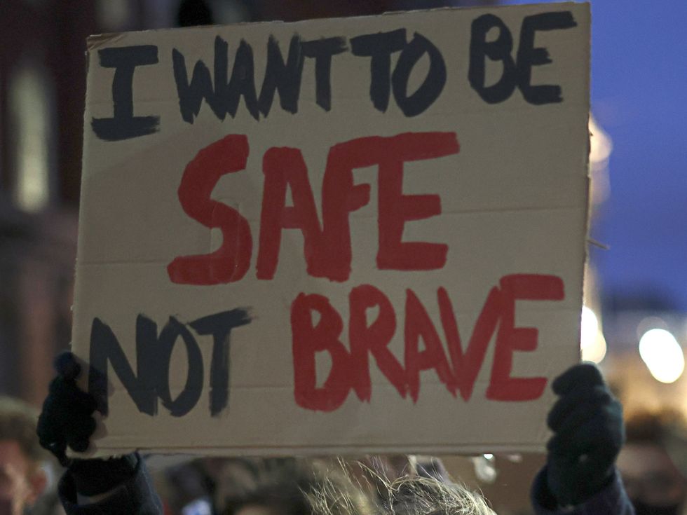 <p>A woman holds up a sign at a protest for women\u2019s safety on the streets</p>