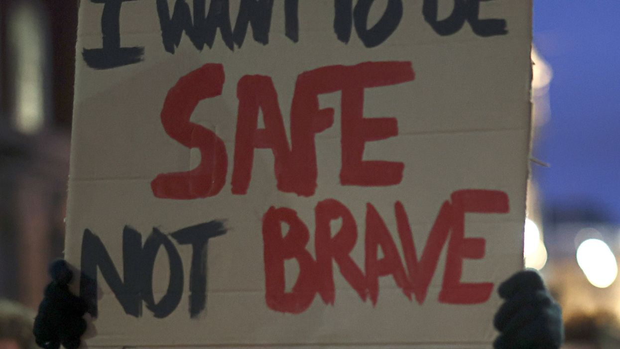 <p>A woman holds up a sign at a protest for women’s safety on the streets</p>
