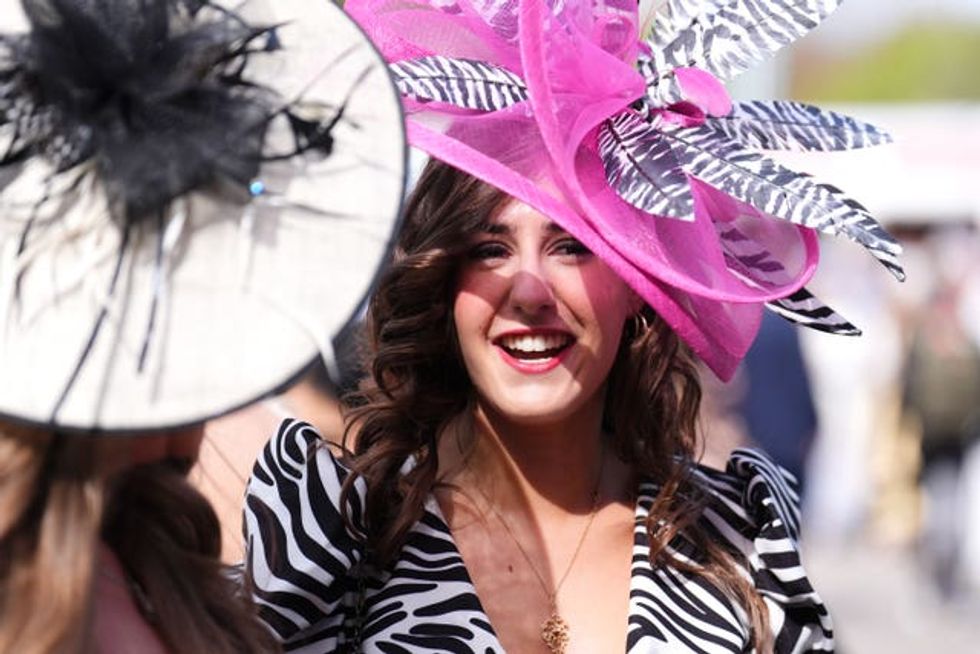 A woman in zebra stripes and a bright pink hat