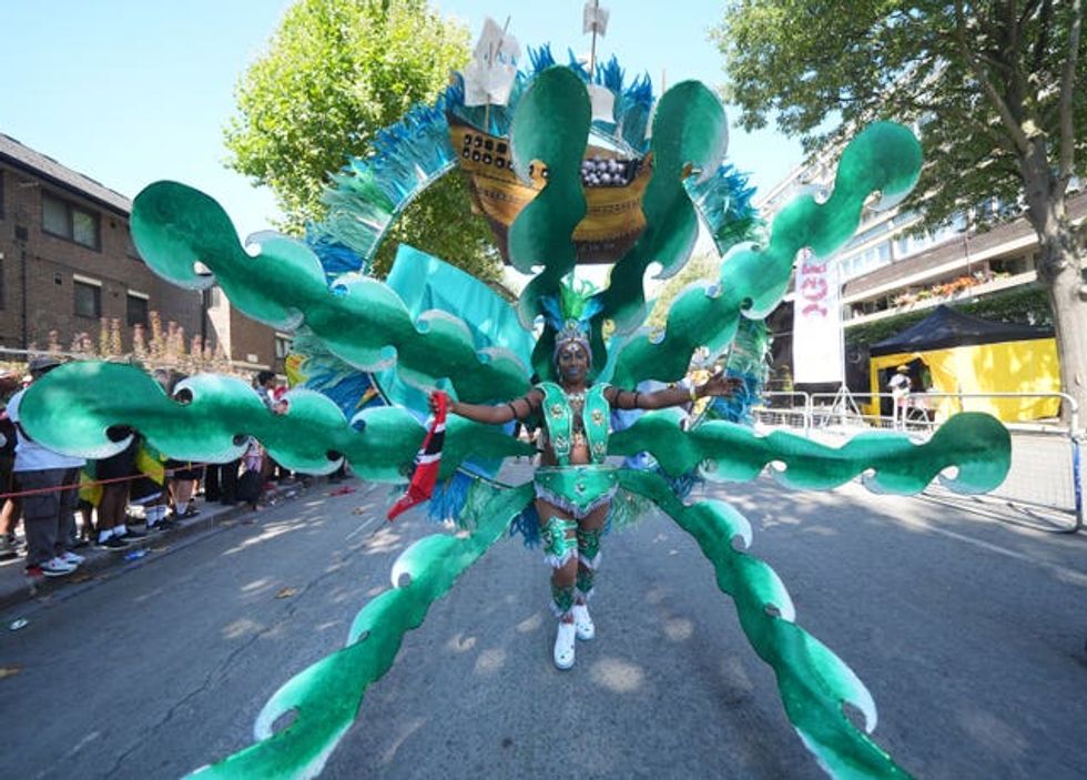 A woman surrounded by massive curls of sea-green waves with a ship over her head