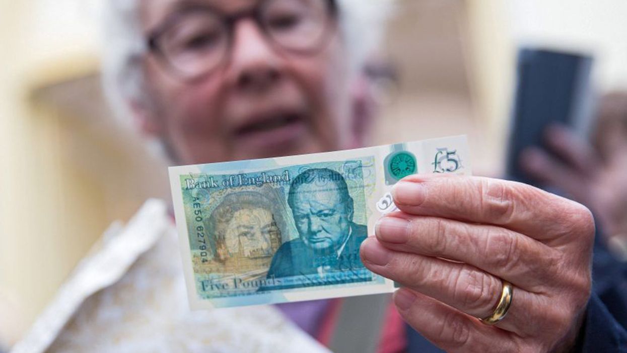 A woman surveys the new polymer £5 note