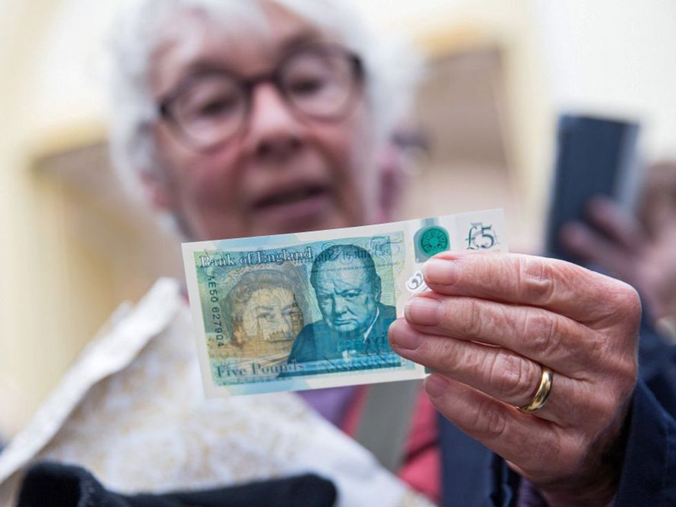 A woman surveys the new polymer \u00a35 note