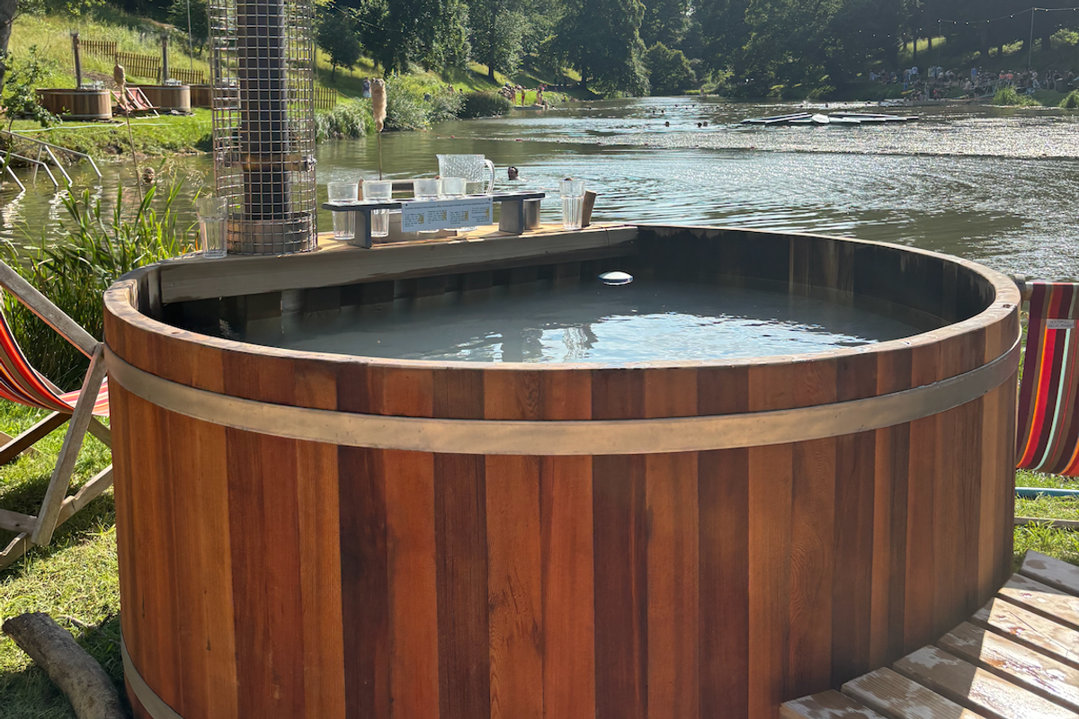 A wooden hot tub overlooks a lake