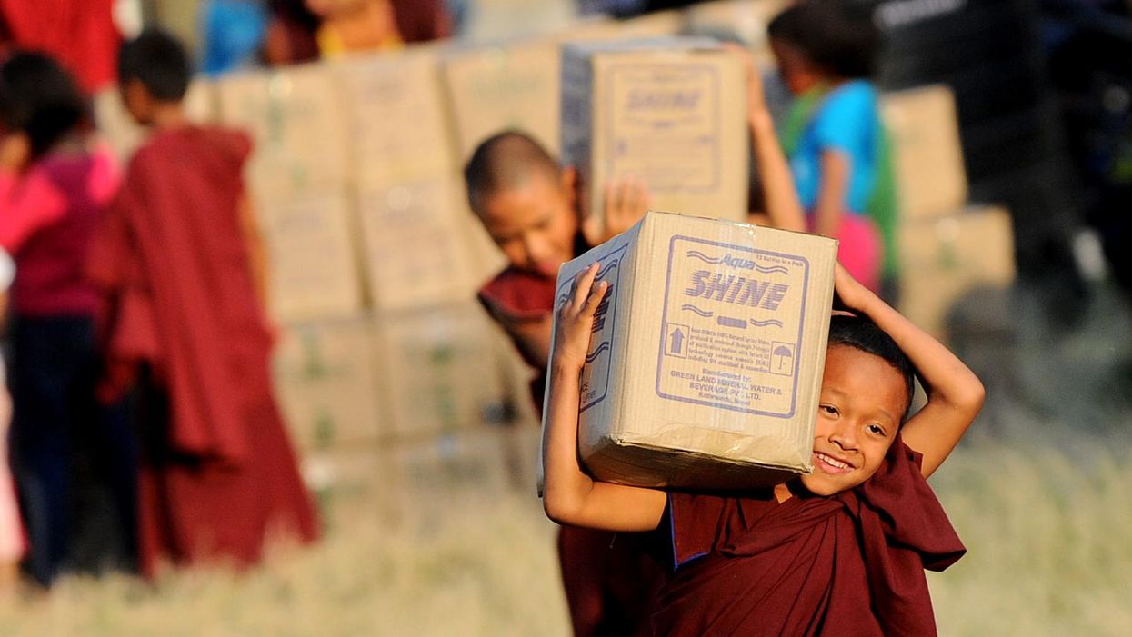 A young Nepalese Buddhist monk carries relief materials at a camp for earthquake survivors in Kathmandu
