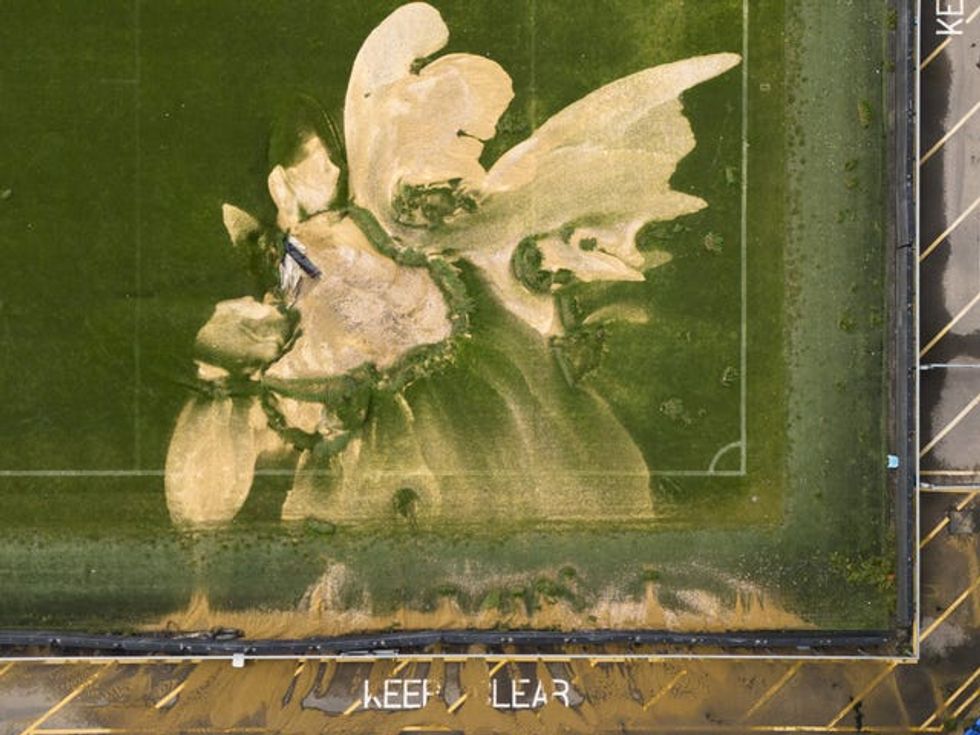 Aerial shot of a the pitch at the Cherry Red Records Stadium where there was a sinkhole after it was hit by flooding