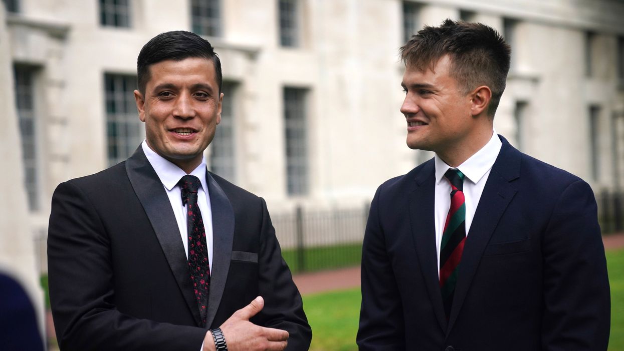 Afghan special operations officer First Lieutenant Mohammad Jawad Akbari, left, and British Army officer Captain Dave Kellett talk to each other by the Iraq Afghanistan Memorial at the Ministry of Defence building in Westminster, central London (Victoria Jones/PA)