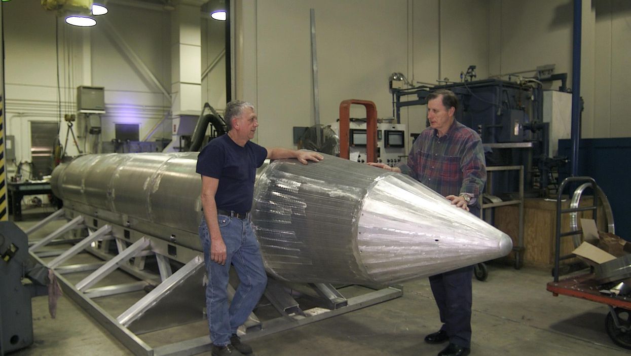 Al Weimorts, the creator of the GBU-43/B Massive Ordnance Air Blast bomb, and Joseph Fellenz, lead model maker, look over the prototype of the bomb before it was painted and tested in March 2003