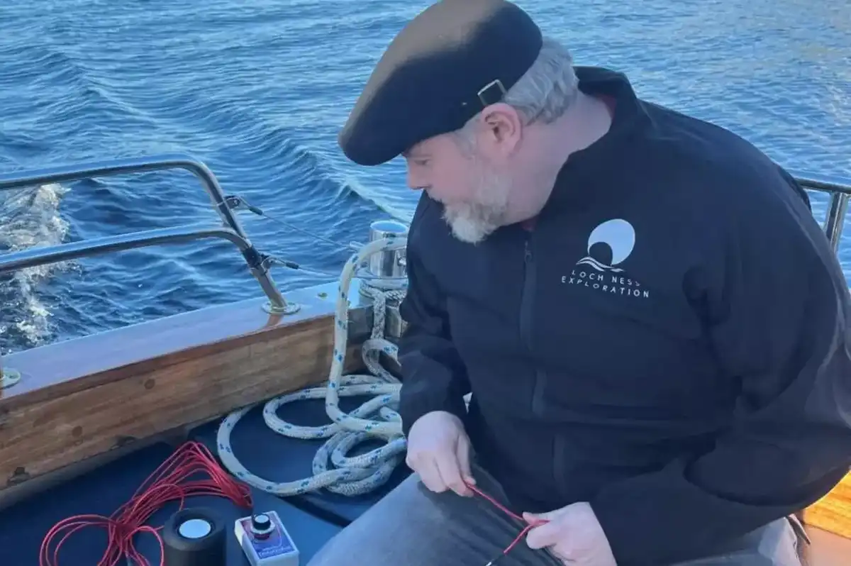 Alan McKenna of Loch Ness exploration sits on a boat using his equipment to detect sound waves under the waters of Loch Ness