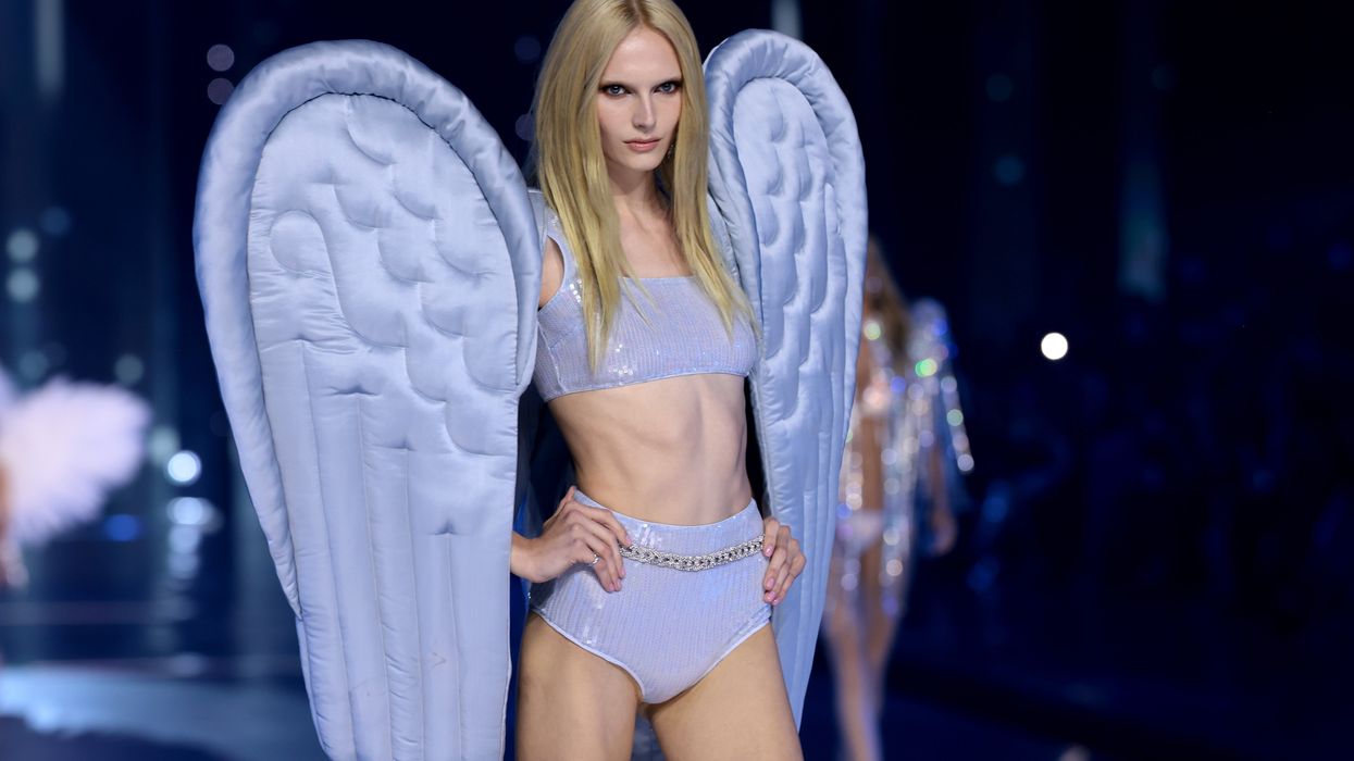 Alex Consani walks in the Victoria's Secret Fashion Show wearing a purple lingerie set and angel wings