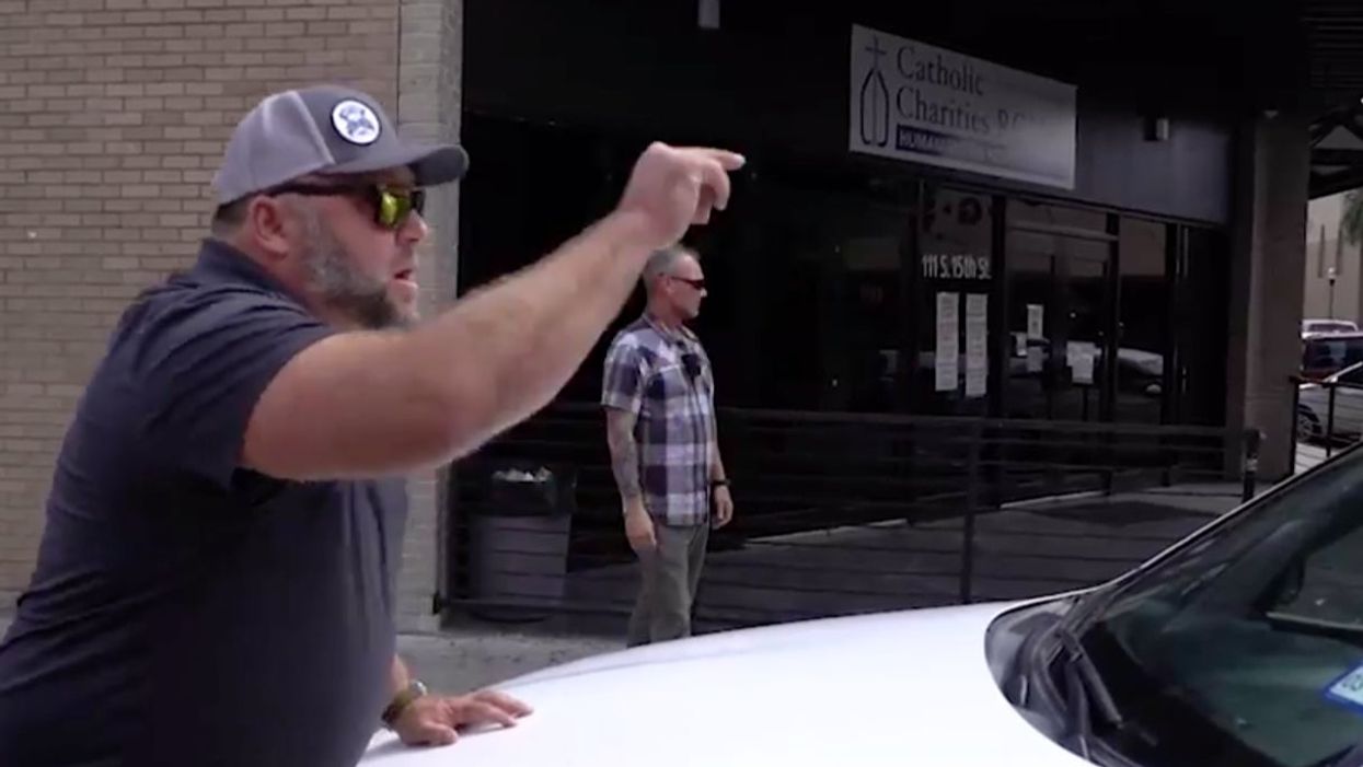 <p>Alex Jones pictured standing in front of the car and shouting</p>