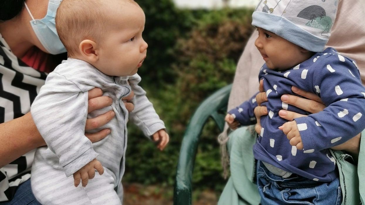 Alexandra Kenchington with her four-month old son, Barney, looking at the four-month old daughter, Madiha, of Afghan refugees (Matt Simmons/PA).