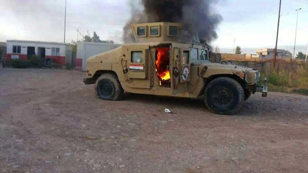 An armoured vehicle belonging to Iraqi security forces in flames in Mosul, June 2014