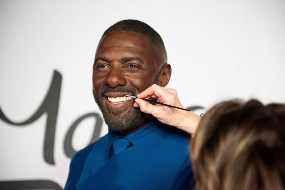 An artist touches up Idris Elba\u2019s waxwork figure at the Baker Street attraction in London