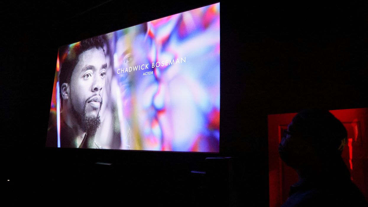 An audience member watches as Chadwick Boseman appears on screen during the annual In Memoriam presentation, at an Oscars watch party at the Stuart & Cinema Cafe, in Brooklyn
