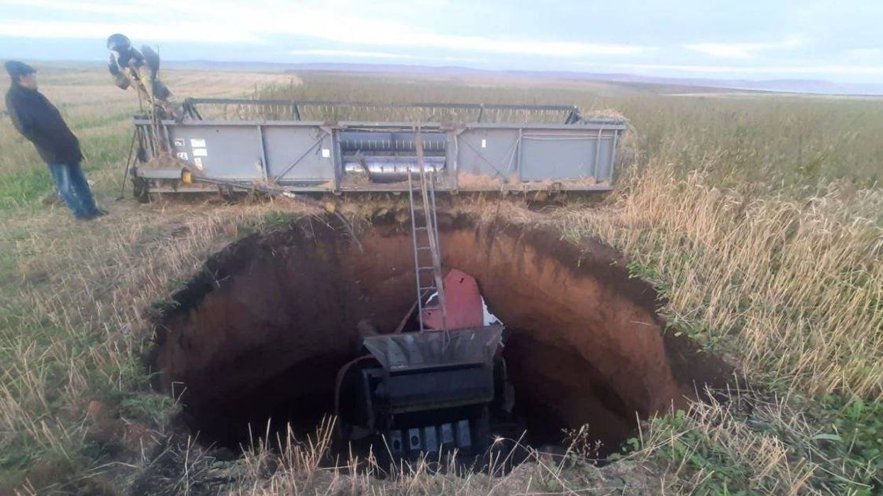 An image of a combine harvester in a sinkhole in Siberia