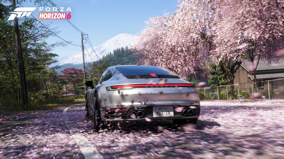 An official screenshot of a Porsche driving through cherry blossom in Forza Horizon 6