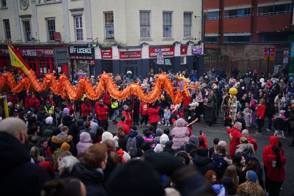 An orange prop is paraded down the centre of standing patrons