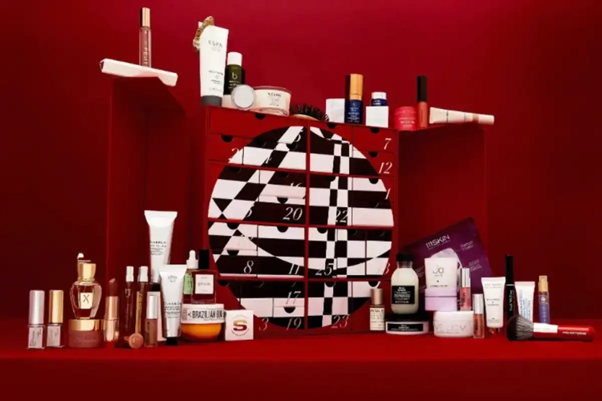 An overview of the products inside the Harvey Nichols beauty advent calendar, including a Jo Loves Candle, Brazilian Bum Bum cream, and Espa skincare.