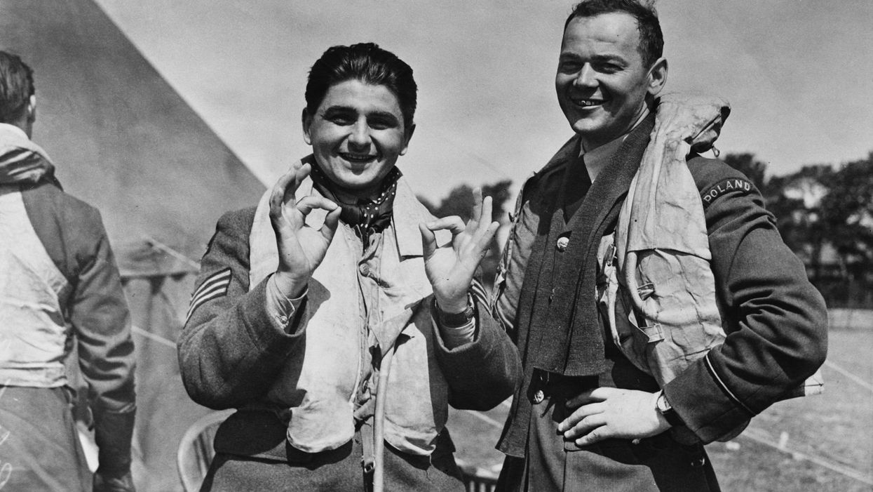 An RAF fighter station in England during the Battle of Britain, World War II, 16th August 1940. Two Polish pilots stationed with the RAF give the OK sign. On the left is Sergeant Glowacki, who has shot down one aircraft, whilst his companion has shot down two.