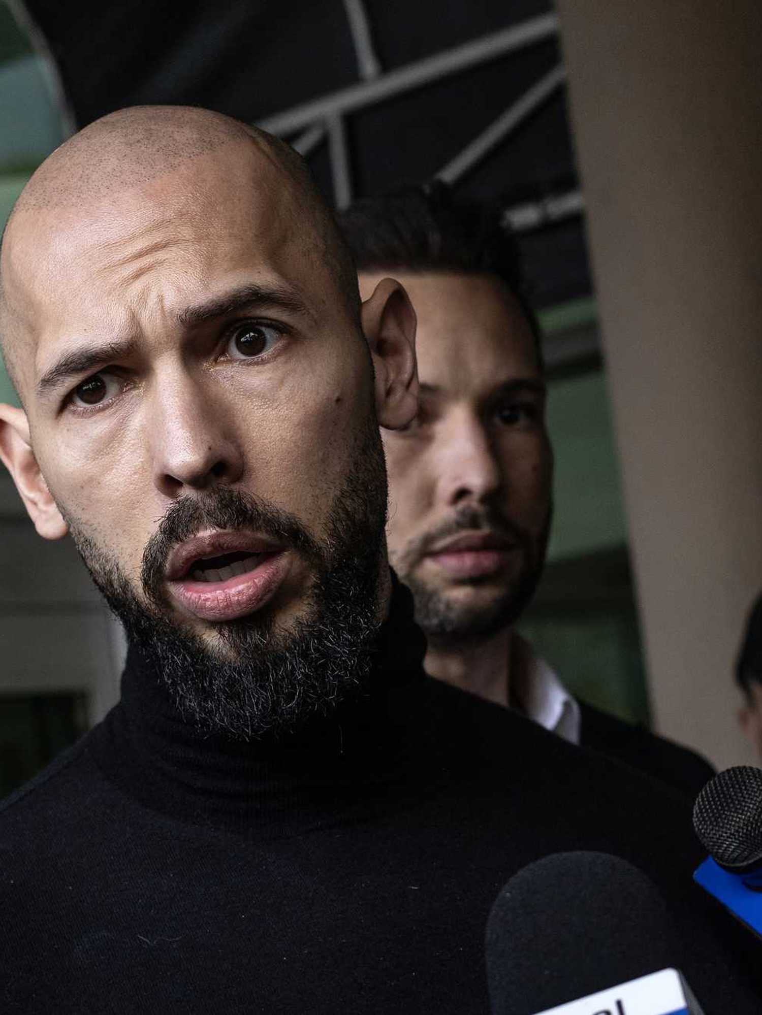 Andrew Tate, a bearded, bald white man.