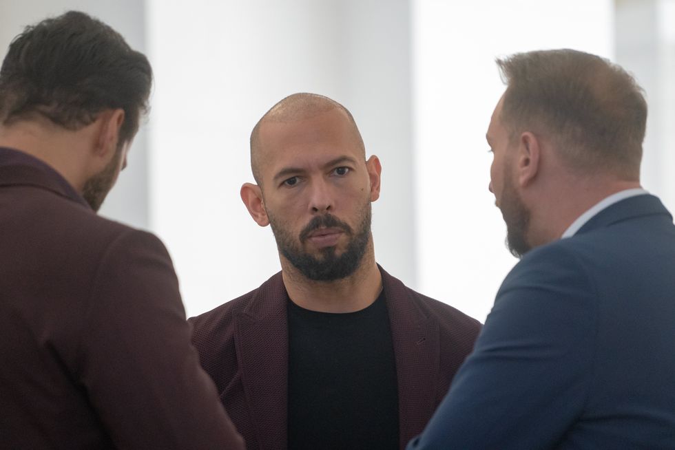Andrew Tate (center) talks to his brother Tristan Tate (left) and to one of his lawyers in the Court of Appeal on October 15, 2024 in Bucharest, Romania